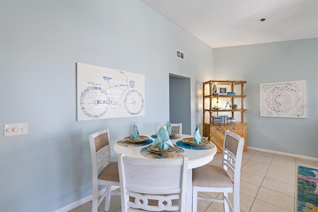 tiled dining area with a textured ceiling