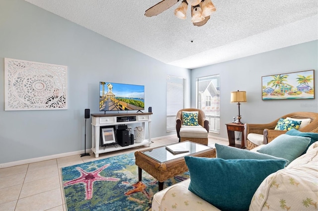 living room with vaulted ceiling, ceiling fan, light tile patterned floors, and a textured ceiling