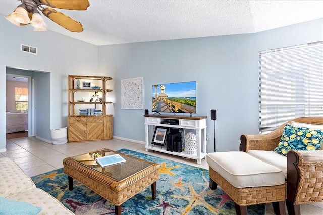 tiled living room featuring a textured ceiling, ceiling fan, and lofted ceiling