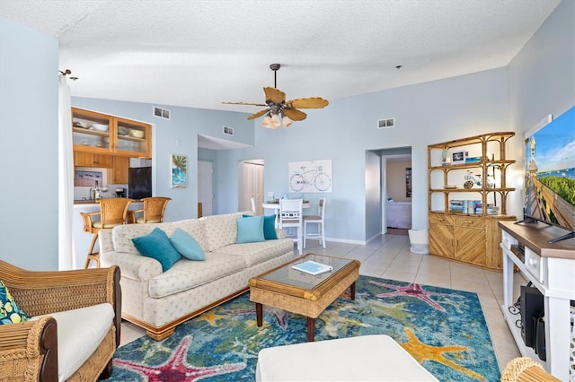 tiled living room with a textured ceiling, ceiling fan, and lofted ceiling