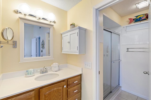 bathroom with tile patterned flooring, a shower with shower door, and a textured ceiling