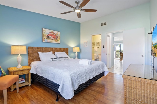 bedroom featuring ceiling fan, light hardwood / wood-style flooring, and ensuite bathroom