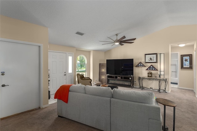 carpeted living room with ceiling fan, lofted ceiling, and a textured ceiling