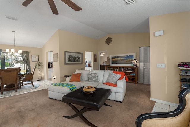 tiled living room featuring a textured ceiling, ceiling fan with notable chandelier, and lofted ceiling