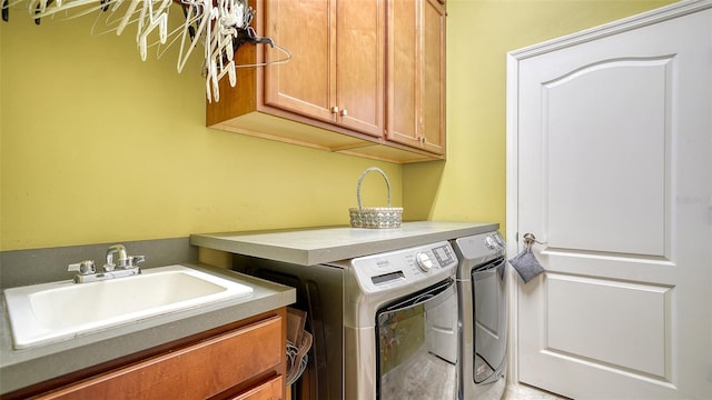 washroom featuring cabinets, independent washer and dryer, and sink