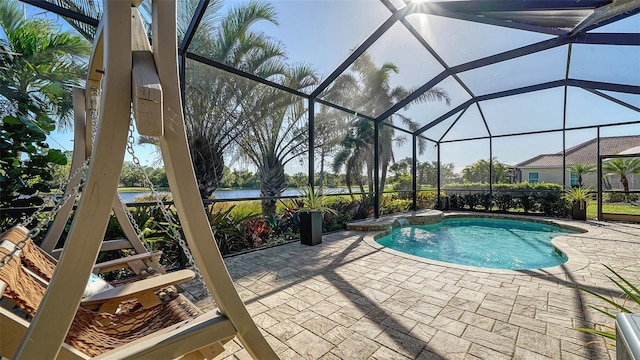 view of pool with a water view, glass enclosure, and a patio area