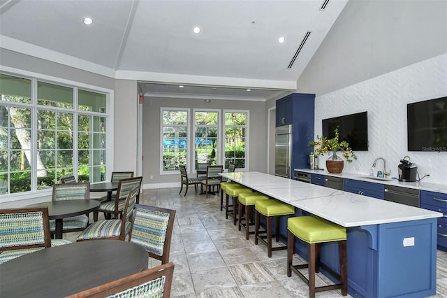 kitchen featuring a center island, sink, vaulted ceiling, blue cabinetry, and stainless steel appliances