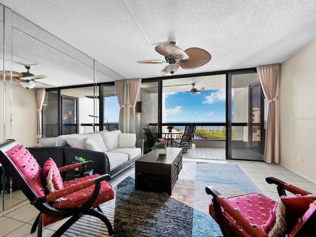 living room featuring light tile patterned floors, a textured ceiling, a wall of windows, and a wealth of natural light