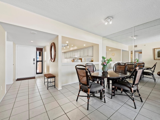 tiled dining room with a textured ceiling