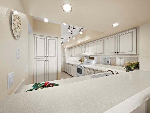 kitchen featuring kitchen peninsula, light tile patterned floors, electric range, and sink