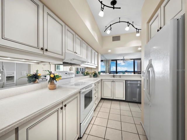 kitchen featuring kitchen peninsula, white appliances, ceiling fan, light tile patterned floors, and white cabinets