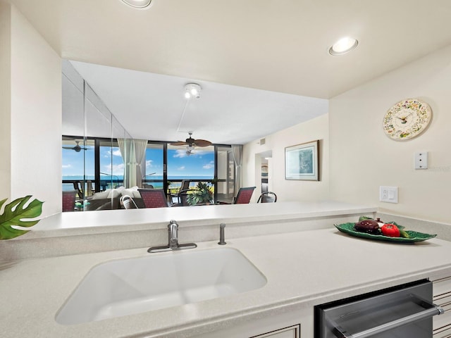 kitchen featuring dishwasher, ceiling fan, kitchen peninsula, and sink