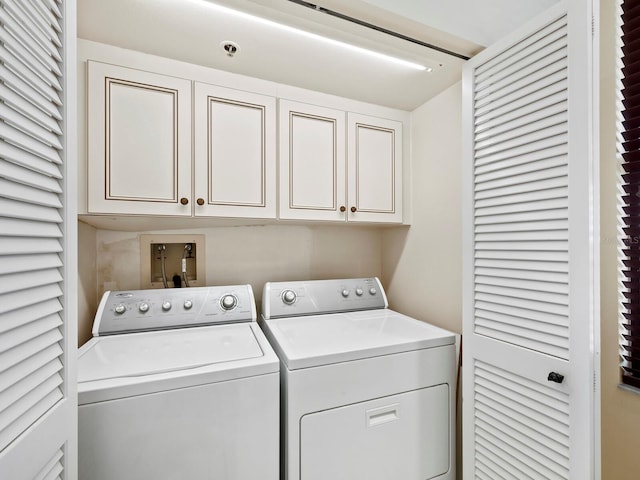 washroom featuring cabinets and separate washer and dryer