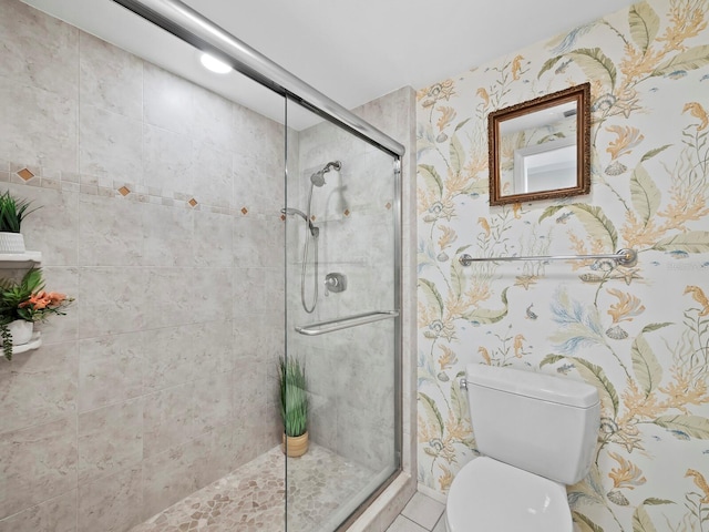 bathroom with tile patterned flooring, a shower with shower door, and toilet