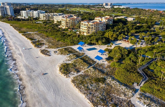 drone / aerial view with a water view and a beach view