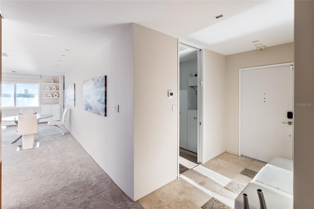 hallway with light colored carpet