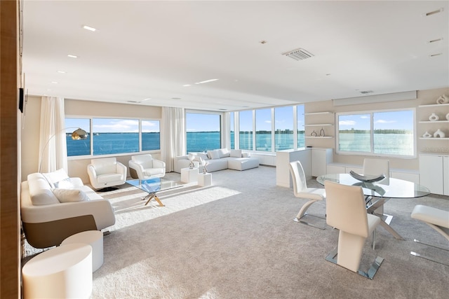 carpeted living room featuring a water view and a healthy amount of sunlight