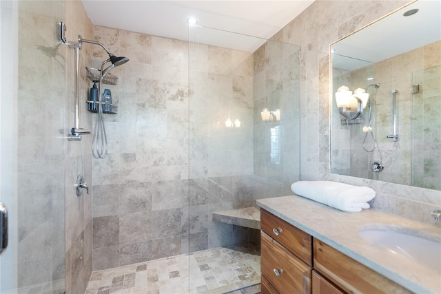 bathroom featuring vanity, an enclosed shower, and tile walls