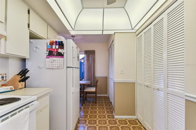 kitchen featuring white cabinetry and white fridge