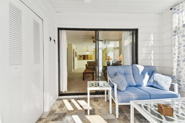 sunroom / solarium featuring ceiling fan and wood ceiling