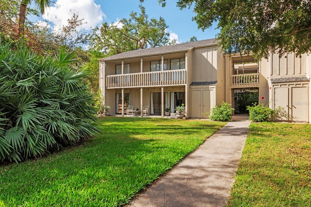 back of house featuring a yard and a balcony