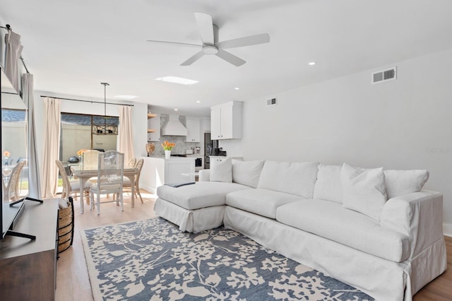 living room featuring ceiling fan and light wood-type flooring