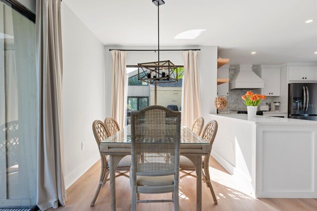 dining area featuring light hardwood / wood-style floors and an inviting chandelier