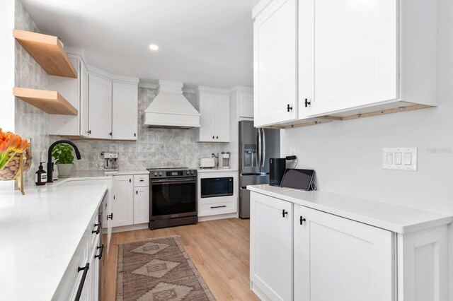 kitchen featuring stainless steel fridge, range with electric cooktop, white cabinets, and custom exhaust hood