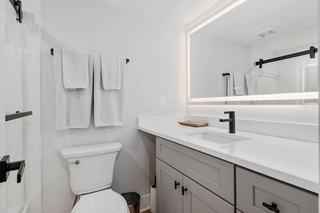 bathroom featuring vanity, toilet, and walk in shower