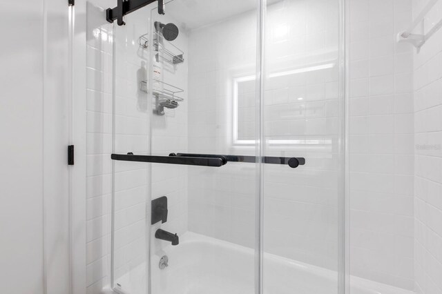 bathroom with shower / bath combination with glass door