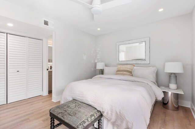 bedroom with ceiling fan, a closet, and light hardwood / wood-style floors