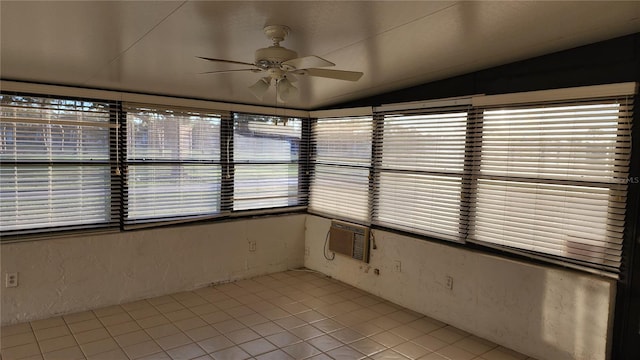 unfurnished sunroom with ceiling fan, a healthy amount of sunlight, an AC wall unit, and vaulted ceiling