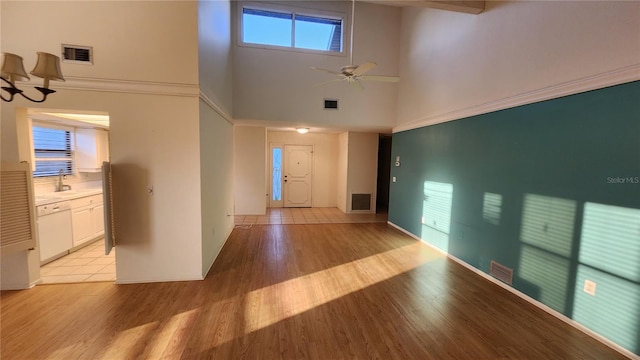 foyer entrance featuring light hardwood / wood-style floors, high vaulted ceiling, ceiling fan, and sink