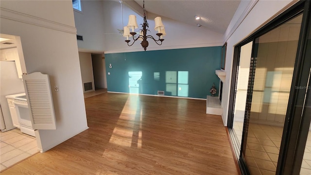 3409 Avenida Madera Unit A, Bradenton, FL 34210 - unfurnished dining area with high vaulted ceiling, a chandelier, light wood-type flooring, and a fireplace