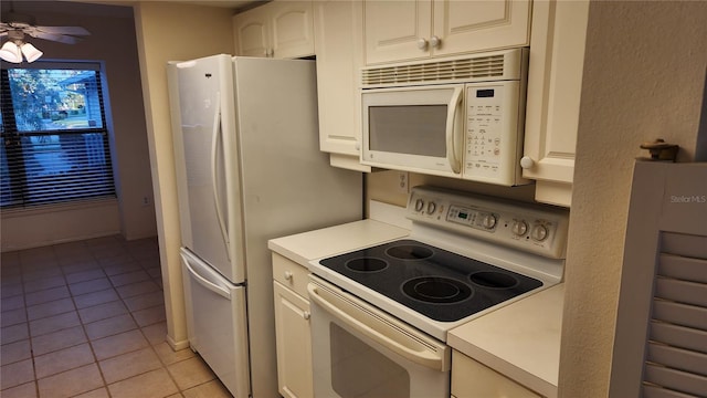 3409 Avenida Madera Unit A, Bradenton, FL 34210 - kitchen with white appliances, light tile patterned floors, light countertops, and white cabinets
