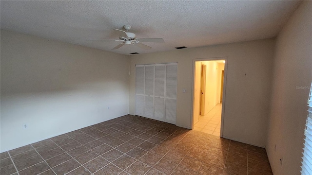 3409 Avenida Madera Unit A, Bradenton, FL 34210 - empty room with a ceiling fan, dark tile patterned flooring, and a textured ceiling