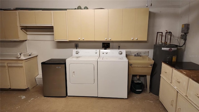 clothes washing area featuring washer and dryer, sink, cabinets, and electric water heater