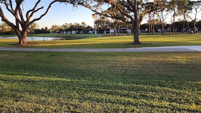 surrounding community with a yard and a water view