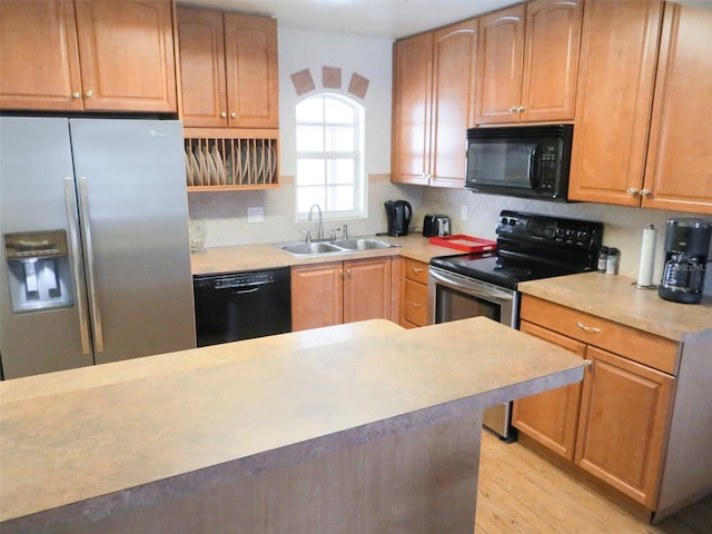 3405 Highland Ave W, Bradenton, FL 34205 - kitchen with black appliances, a sink, light countertops, and backsplash