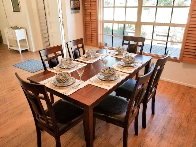 dining space with baseboards and wood finished floors