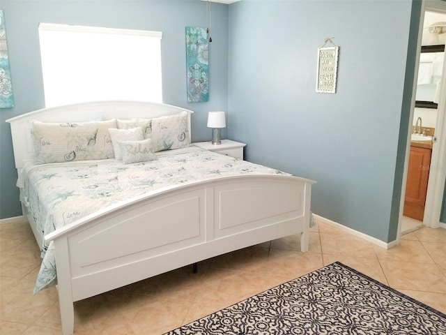 bedroom featuring ensuite bathroom, sink, and light tile patterned floors