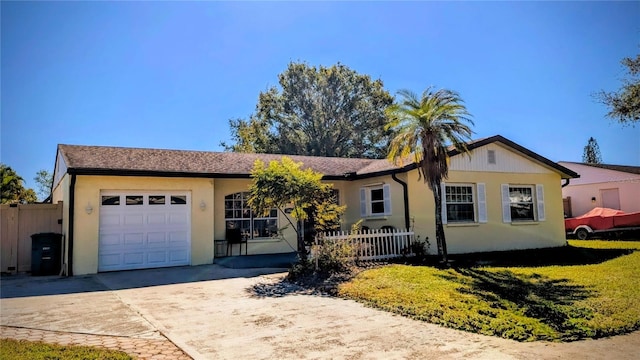 ranch-style home with a garage, driveway, a front lawn, and fence