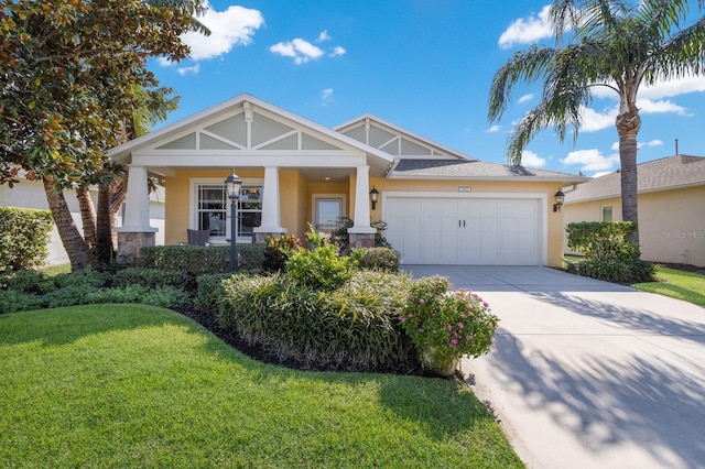 craftsman-style house featuring covered porch, a garage, and a front yard