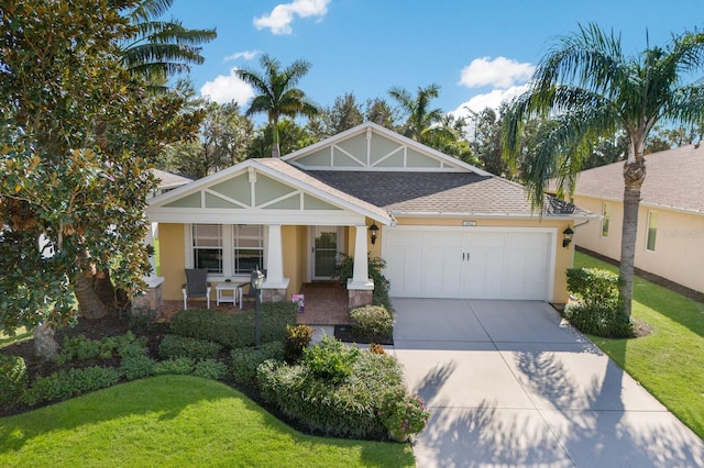 view of front of home with a front lawn, covered porch, and a garage