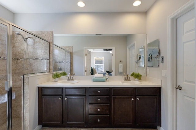 bathroom with a tile shower and vanity