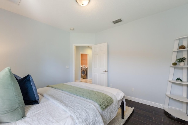 bedroom with washer and clothes dryer and dark hardwood / wood-style flooring