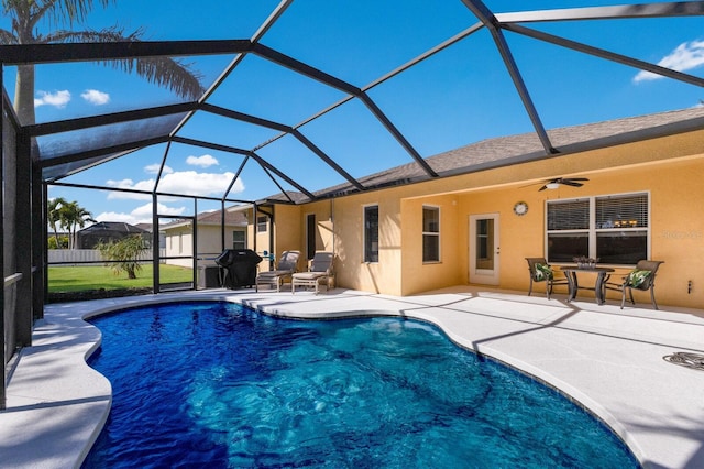 view of swimming pool with ceiling fan, a patio area, and a lanai