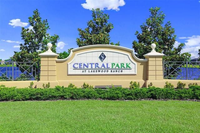 community / neighborhood sign with a yard and a water view