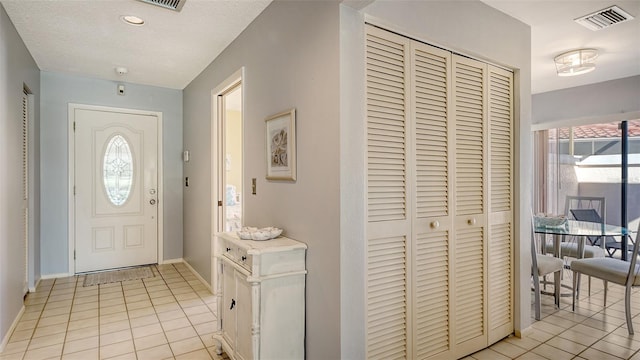 tiled foyer featuring a textured ceiling