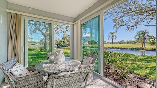 sunroom featuring a water view